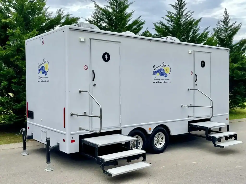 VannGo portable restroom trailer with accessible ramps and branding.